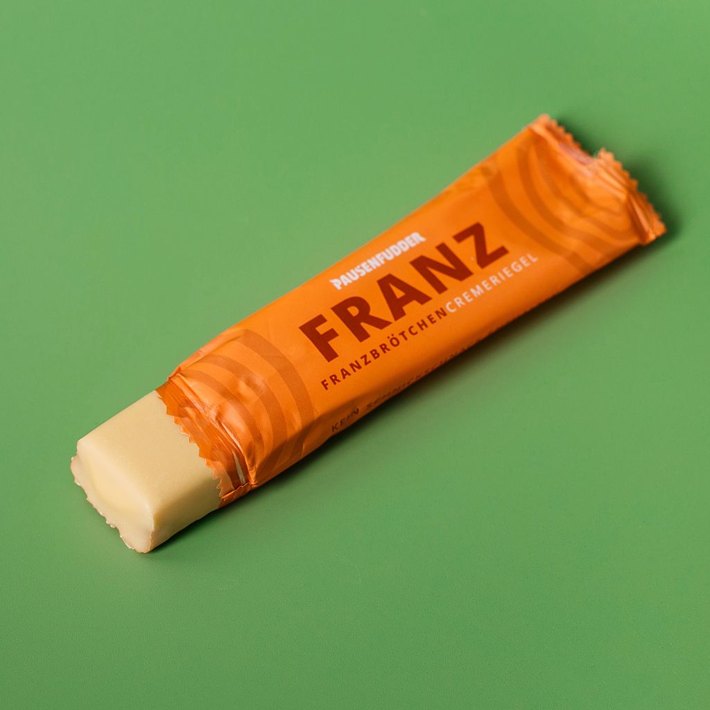 weißer schokoriegel mit Franzbrötchengeschmack. Vegan und bio. In orangener Verpackung. Name: Franz